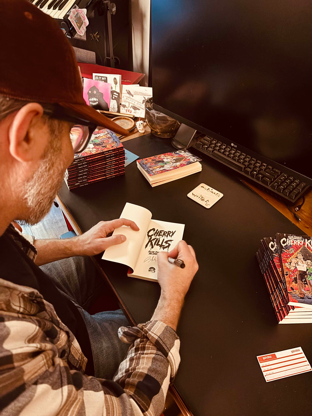 Man sitting at a desk signing books