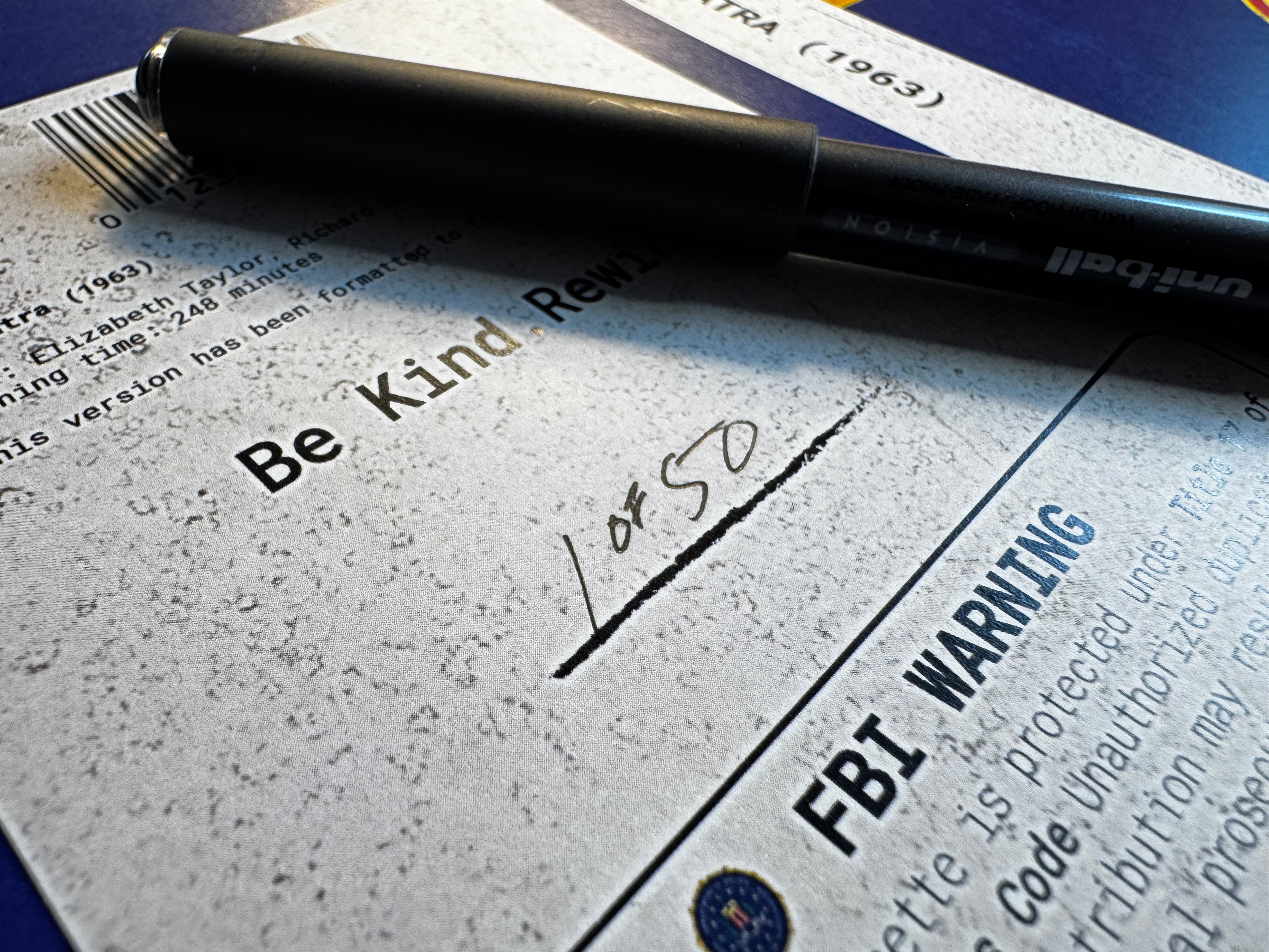 Pen on a piece of paper with text and 'FBI Warning' label