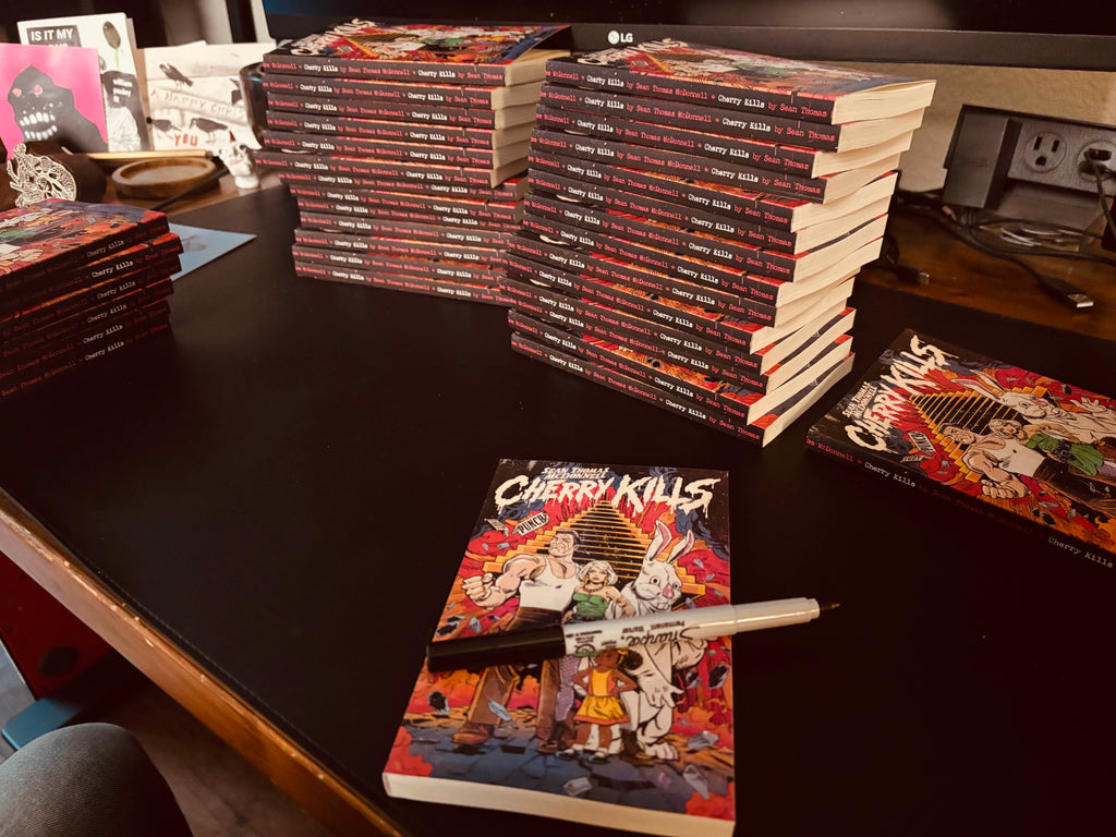 Stacks of books on a table with 'Cherry Kills' visible